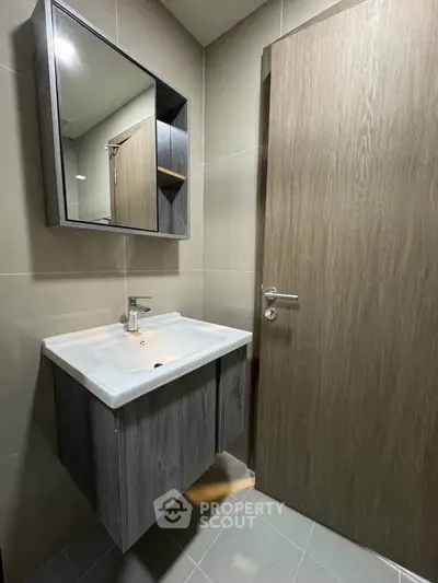 Modern bathroom with sleek vanity and mirror in contemporary design.