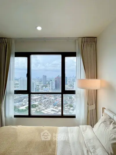Stunning bedroom with panoramic city view from a high-rise window, featuring cozy bedding and elegant curtains.