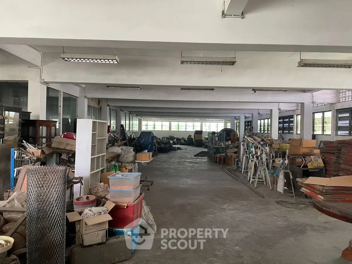 Spacious industrial storage area with ample natural light and organized shelving.