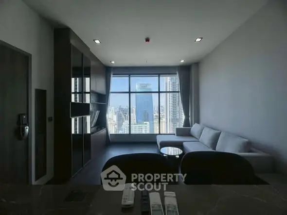 Modern living room with large window offering stunning city view, featuring sleek furniture and contemporary design.