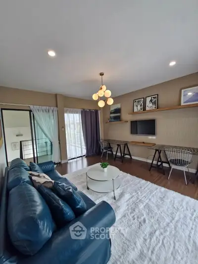 Stylish living room with modern decor, blue sofa, and wall-mounted TV, perfect for relaxation and entertainment.