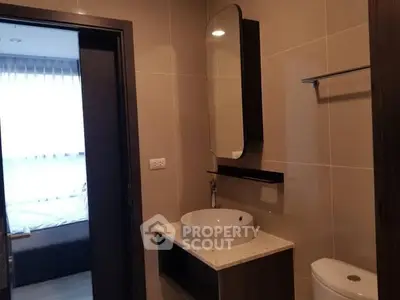 Modern bathroom with sleek fixtures and a glimpse of a cozy bedroom.