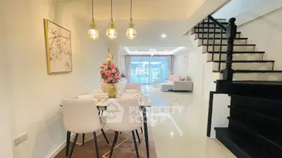 Elegant open-plan living and dining area with modern decor and staircase