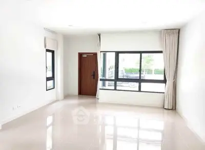 Bright and spacious living room with large windows and modern design.