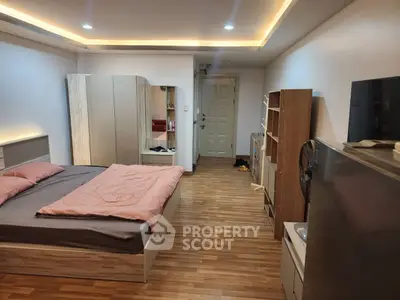 Modern bedroom with stylish lighting and wooden flooring, featuring a cozy bed and ample storage space.