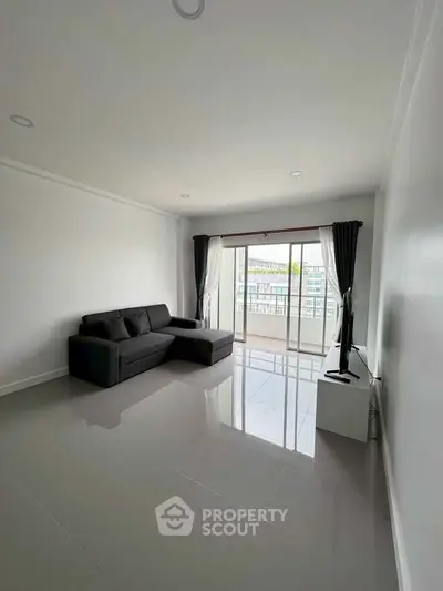 Spacious modern living room with sleek sofa and large window view