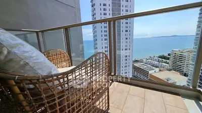 Stunning balcony view with ocean and cityscape, perfect for relaxation.