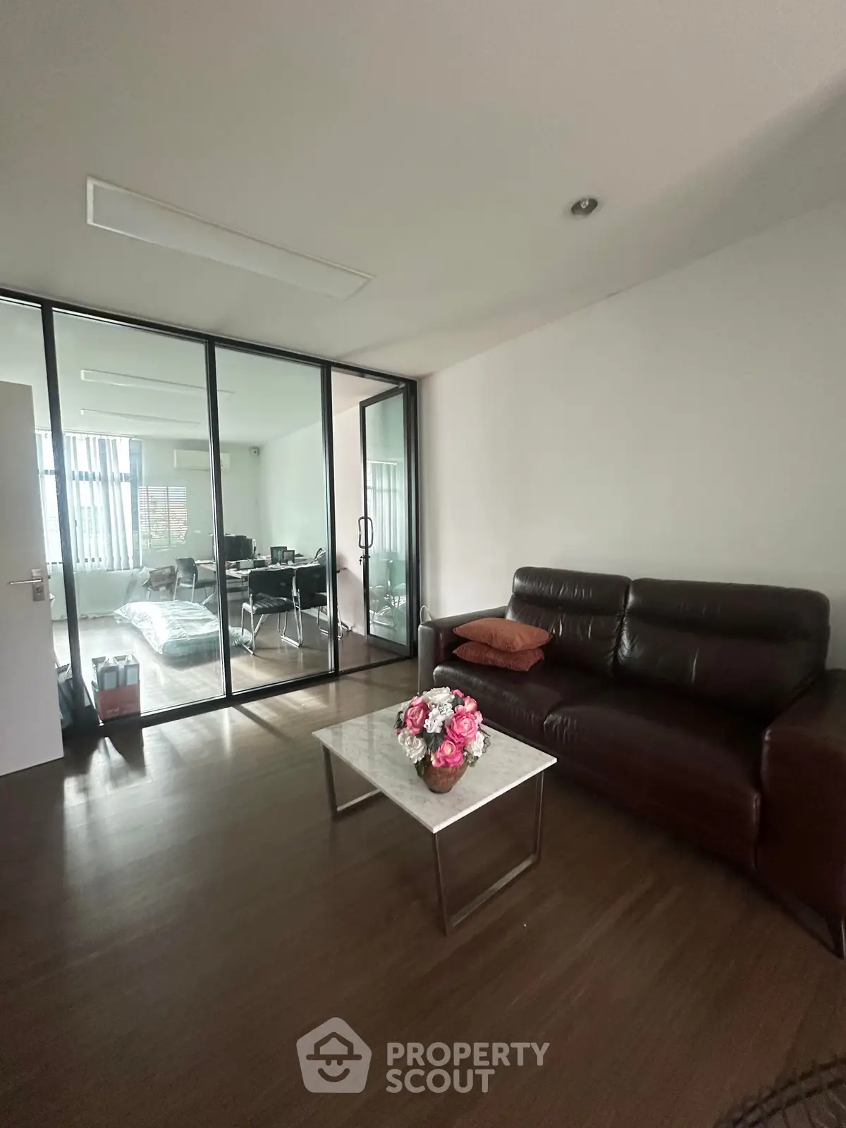 Modern living room with glass partition and leather sofa in a stylish apartment