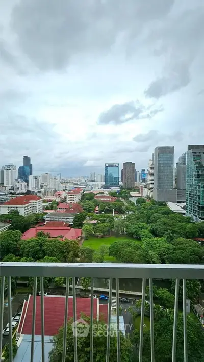 Stunning cityscape view from a high-rise balcony overlooking lush greenery and modern skyscrapers.