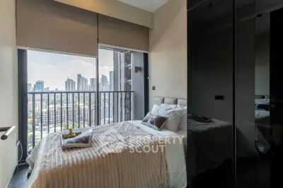 Modern bedroom with stunning city view and cozy decor in high-rise apartment.