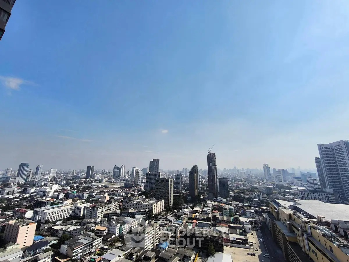 Stunning cityscape view from a high-rise building, showcasing urban skyline and clear blue sky.