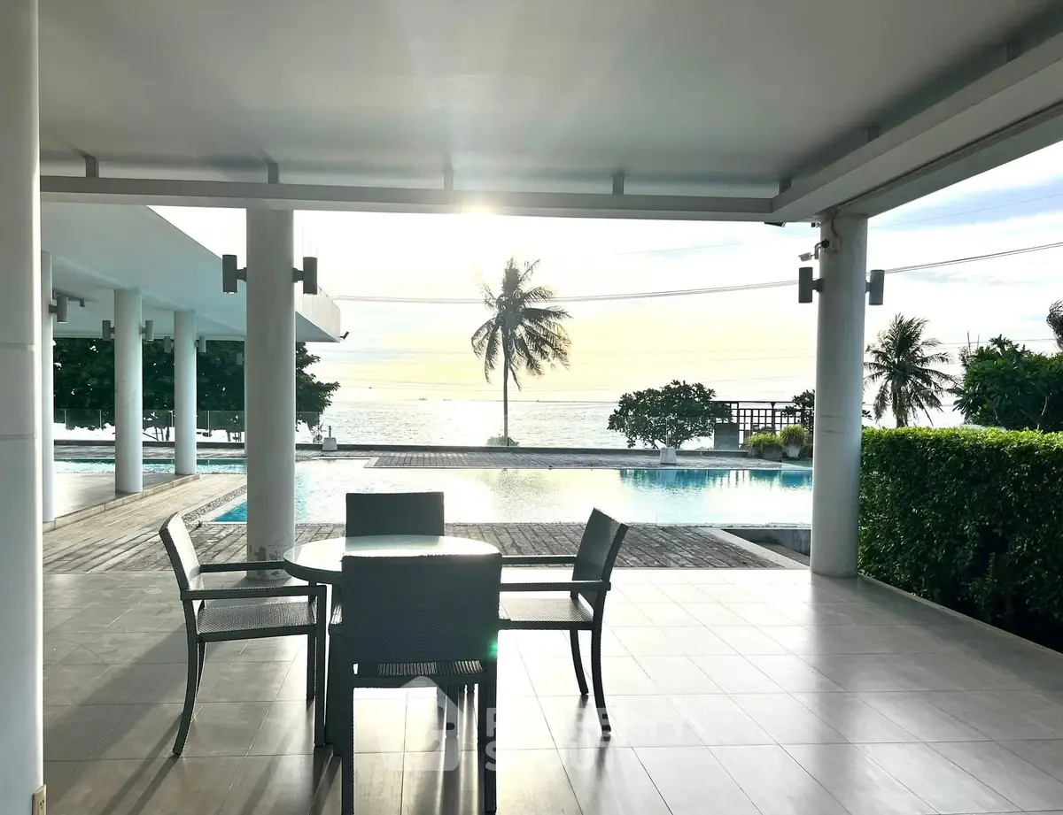 Stunning beachfront poolside view with outdoor seating and ocean backdrop.