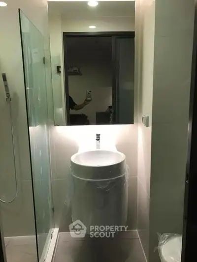 Modern bathroom with sleek sink and glass shower enclosure, perfect for contemporary living.