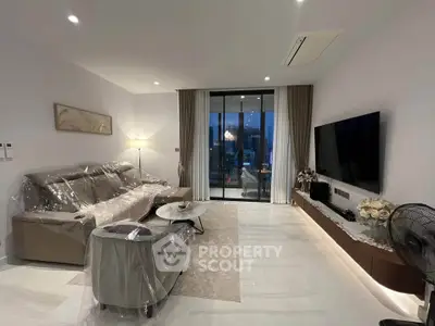 Modern living room with elegant decor and city view balcony, featuring a large TV and stylish furniture.