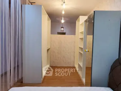 Spacious walk-in closet with ample shelving and modern lighting