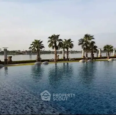 Luxurious waterfront pool with palm trees and serene lake view