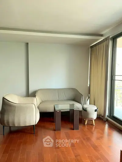 Modern living room with sleek furniture and large window for natural light.