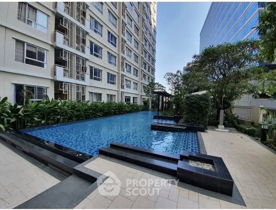 Luxurious condominium with stunning outdoor pool and lush greenery, perfect for relaxation and leisure.