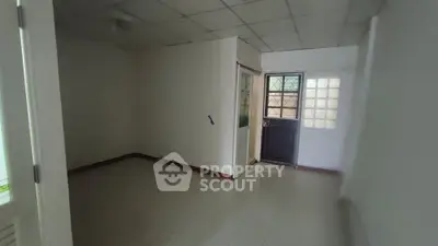 Spacious room with tiled floor and natural light, ideal for versatile use in a real estate property.