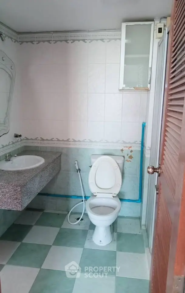 Spacious bathroom with modern fixtures and tiled flooring in a real estate property.