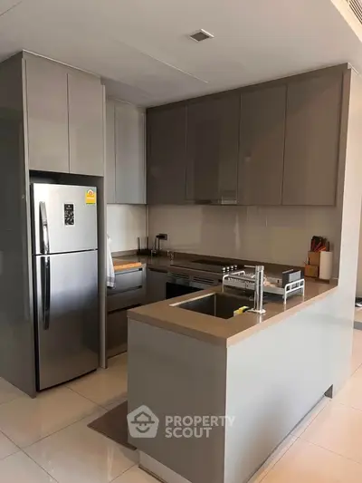 Modern kitchen with sleek cabinetry and stainless steel appliances in a contemporary apartment.