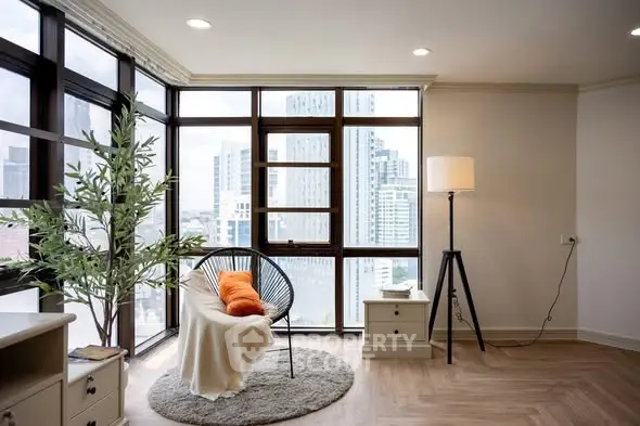 Modern living room with city view, stylish chair, and cozy decor