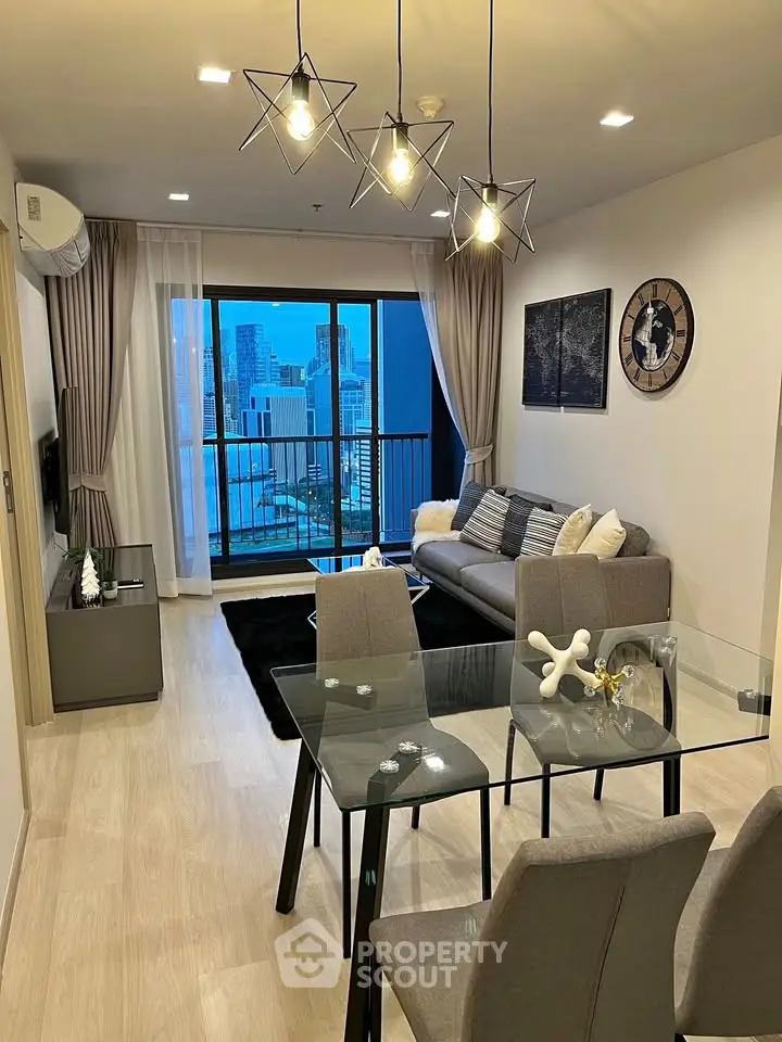 Modern living room with stylish decor and city view balcony in high-rise apartment.