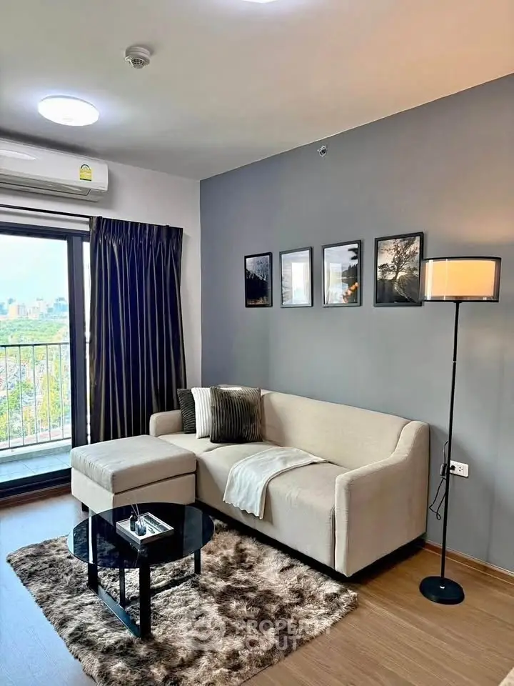 Modern living room with cozy sofa, stylish decor, and balcony view in urban apartment.