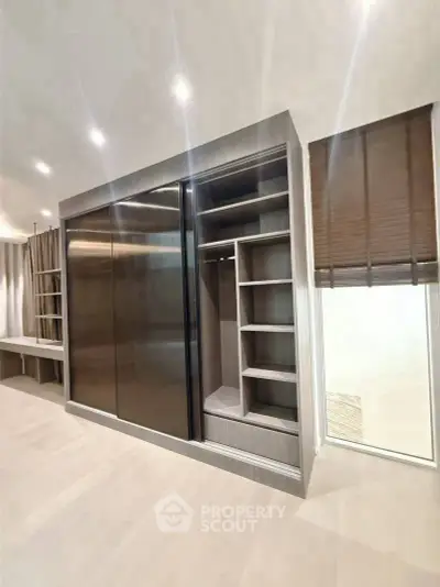 Spacious modern wardrobe with sleek sliding doors and ample storage space.