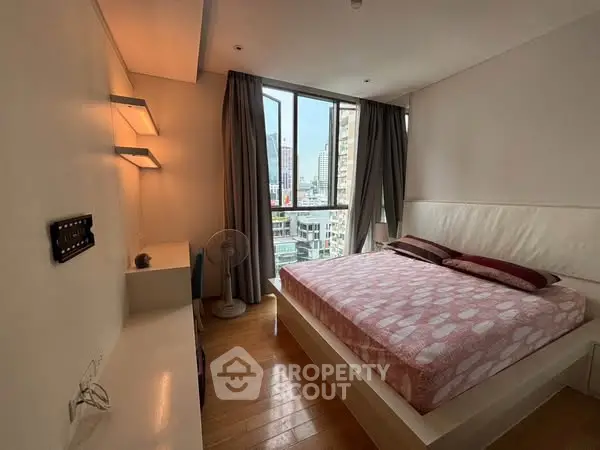 Modern bedroom with city view, featuring cozy bed and stylish lighting.