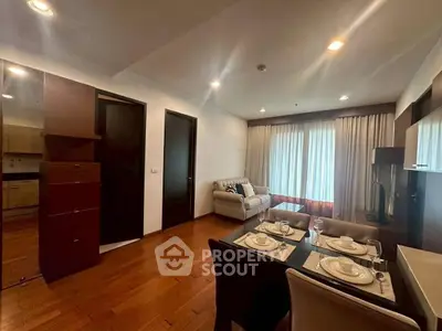 Modern living room with dining area and cozy seating, featuring elegant wooden flooring.