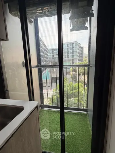 Compact balcony with artificial grass and city view from modern apartment