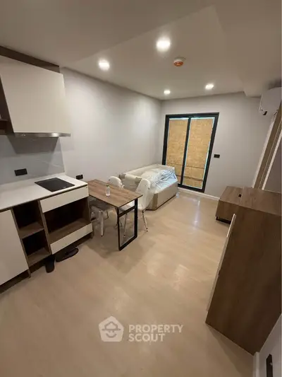 Modern living room with open kitchen layout and cozy seating area