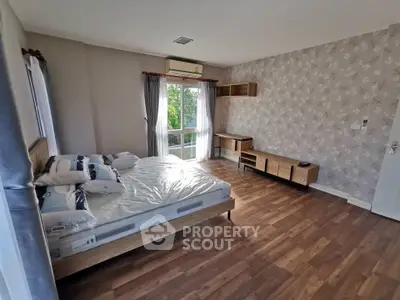 Spacious bedroom with modern decor and large window view