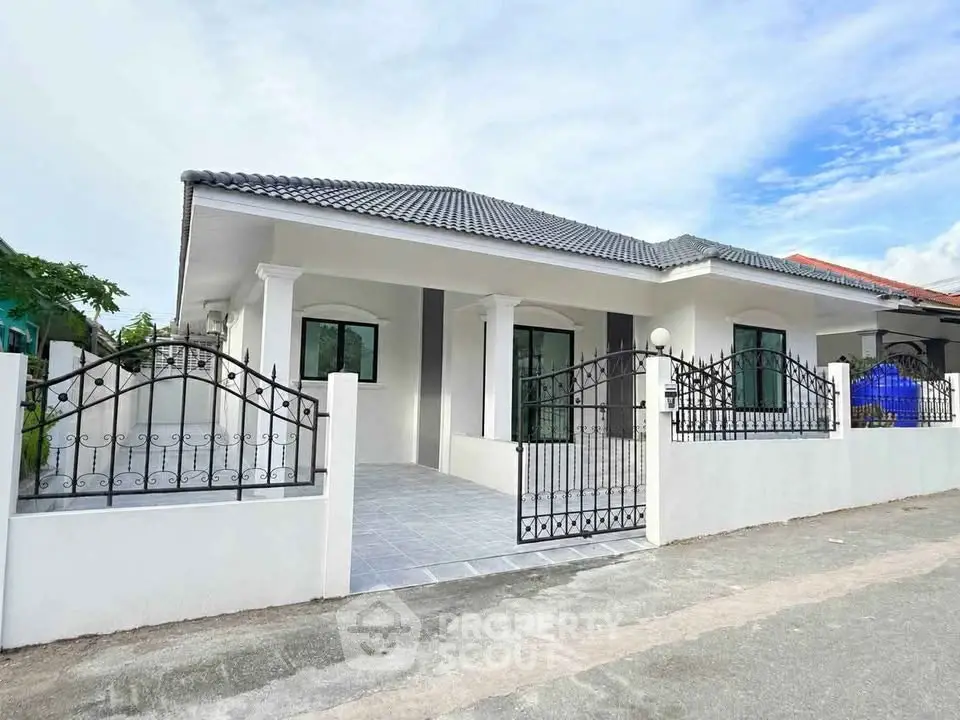 Charming single-story home with elegant iron gate and spacious driveway in a serene neighborhood.