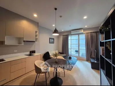 Modern living room with open kitchen, stylish decor, and balcony view in a contemporary apartment.