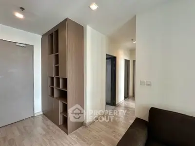 Modern apartment interior with sleek wooden shelving and cozy seating area.
