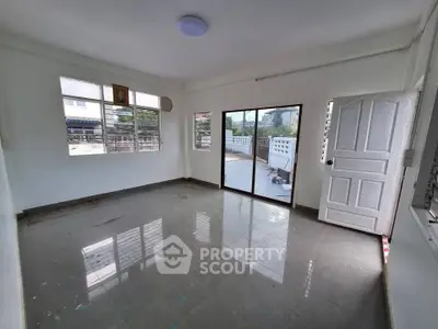 Spacious unfurnished room with large windows and balcony access, perfect for customization.