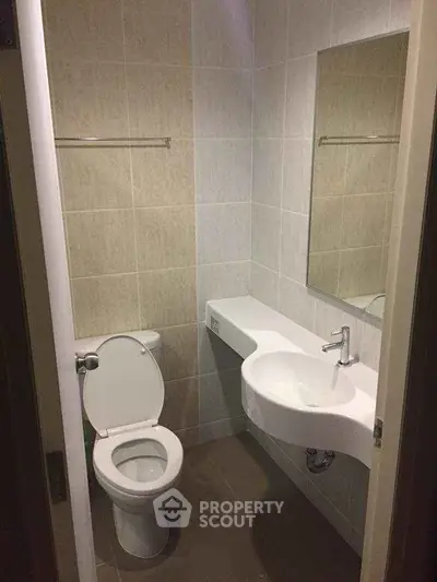 Compact bathroom with modern fixtures and neutral tiles, ideal for small spaces.