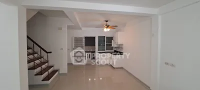 Spacious open-plan living area with modern kitchen and staircase