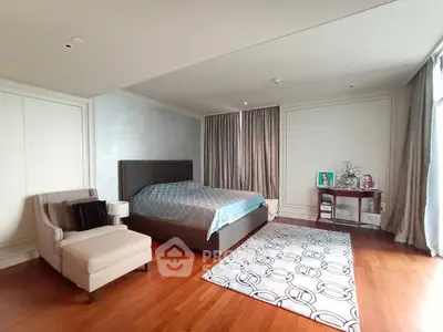 Spacious bedroom with elegant decor and large windows in luxury apartment.