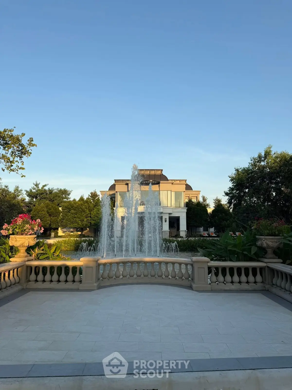 Luxurious mansion with elegant fountain and lush landscaping