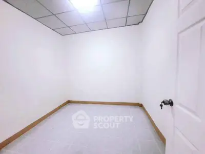 Spacious empty room with tiled floor and white walls, ideal for customization.