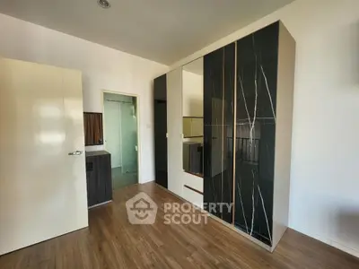 Modern bedroom with sleek wardrobe and wooden flooring