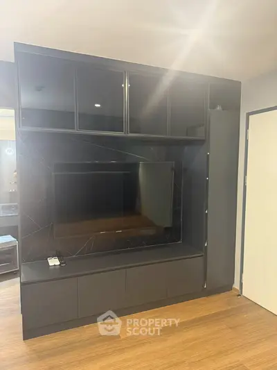Modern living room with sleek built-in entertainment center and flat-screen TV.