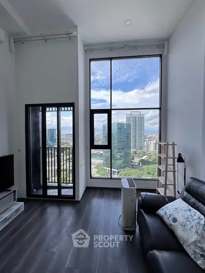 Modern living room with floor-to-ceiling windows offering stunning cityscape views and sleek dark flooring.