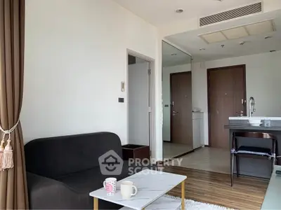Modern living room with sleek black sofa and marble coffee table in a bright apartment.