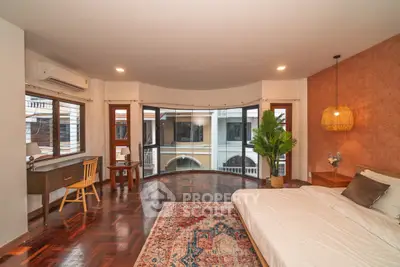 Spacious bedroom with large windows and elegant wooden flooring