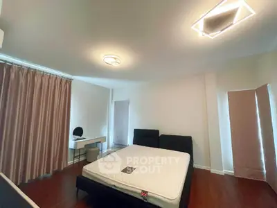 Spacious bedroom with modern lighting and elegant curtains