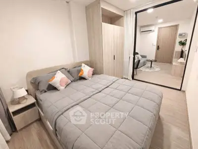 Modern bedroom with cozy decor and sliding glass door leading to living area.
